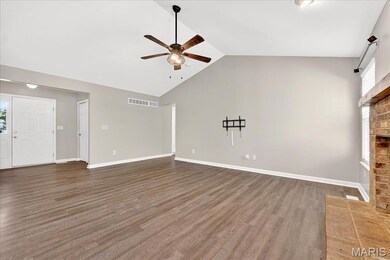 Unfurnished living room with dark wood finished floors, ceiling fan, a fireplace, and high vaulted ceiling