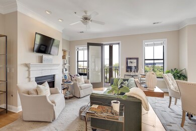 Living room with crown molding, a fireplace, ceiling fan, light wood-style floors, and recessed lighting