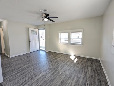 Unfurnished room with dark wood-type flooring, a ceiling fan, and a textured ceiling