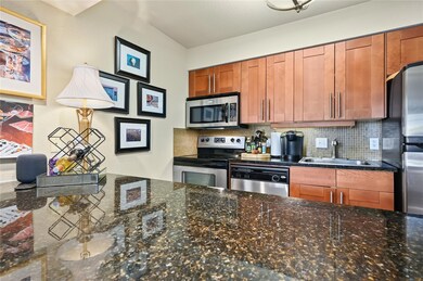 Kitchen with a sink, dark stone countertops, brow