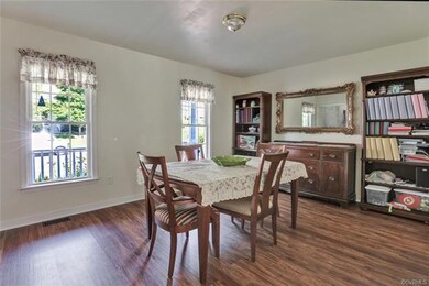 A formal dining room with new flooring and plenty of light