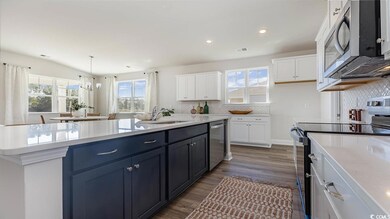 Kitchen with white cabinetry, appliances with stai
