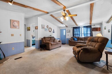 Living area with light carpet and a ceiling fan