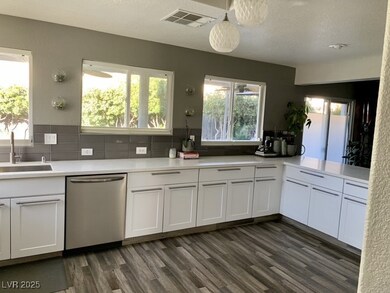 Kitchen with dishwasher, a sink, dark wood-style f
