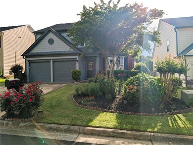 Traditional-style house featuring a standing seam roof, driveway, a metal roof, a front yard, and an attached garage