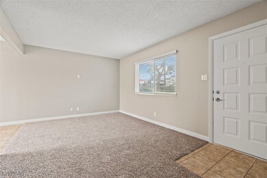 Carpeted entryway with a textured ceiling, baseboa