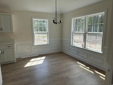 Unfurnished dining area featuring a wainscoted wal