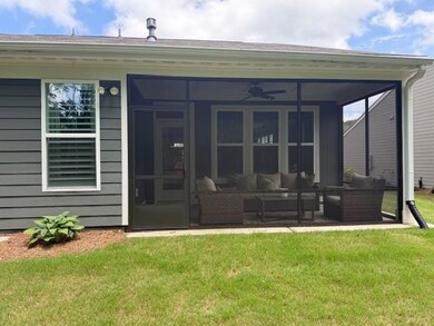 Rear view of property featuring outdoor lounge area, a lawn, and a sunroom