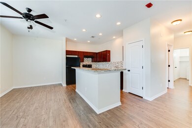 Kitchen featuring black fridge, ceiling fan, light