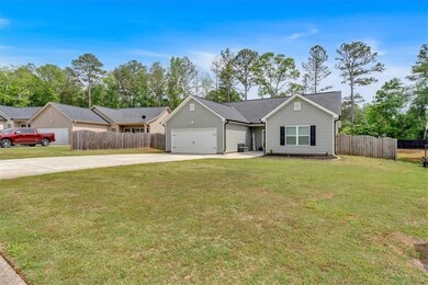 Ranch-style home with an attached garage, fence, a