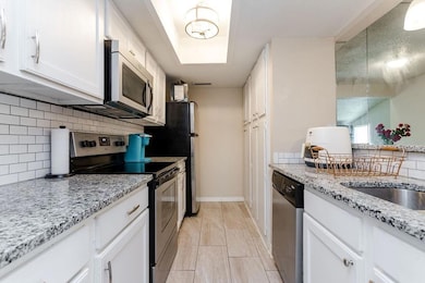 Kitchen with baseboards, decorative backsplash, li