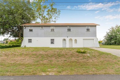 View of front of property featuring driveway, a garage, a front yard, and stucco siding