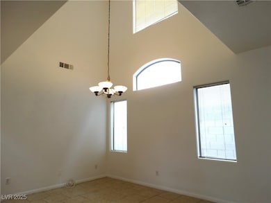 Empty room with an inviting chandelier, a towering