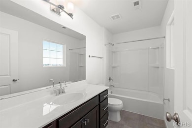 Full bathroom with tile patterned floors, vanity,  shower combination, and toilet
