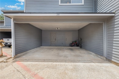 Garage featuring a carport and driveway