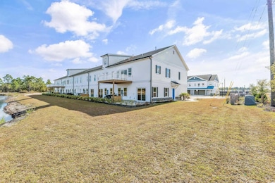Rear view of house featuring a lawn and a water view