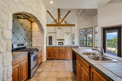 Kitchen with gas range, tile countertops, high va
