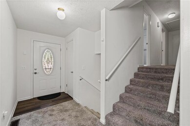 Entrance foyer with a textured ceiling, carpet flo
