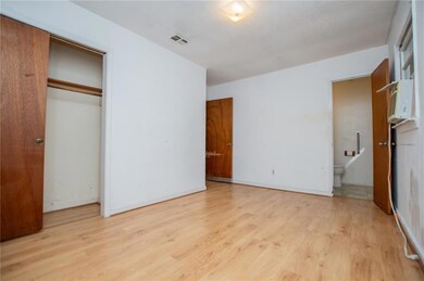 Unfurnished bedroom with light wood-type flooring, a closet, and ensuite bathroom