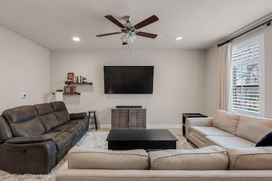 Living room featuring baseboards, ceiling fan, an