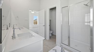Full bath featuring double vanity, a stall shower, and ceiling fan