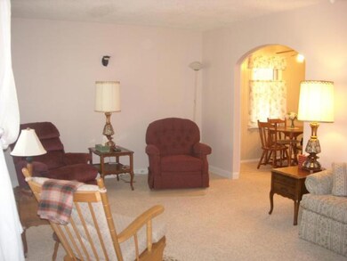 Living room is spacious and features curved doorwa