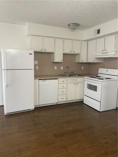 Kitchen featuring stove, a sink, ventilation hood,