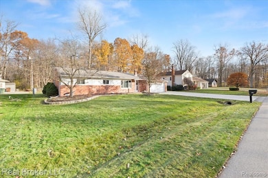 Ranch-style house featuring a front lawn, driveway, and a garage