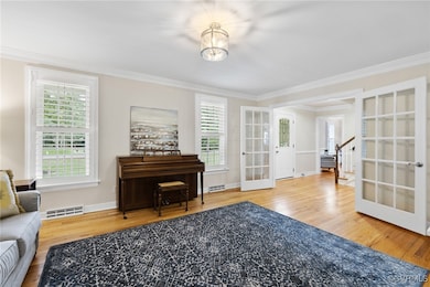 Living area featuring french doors, crown molding,