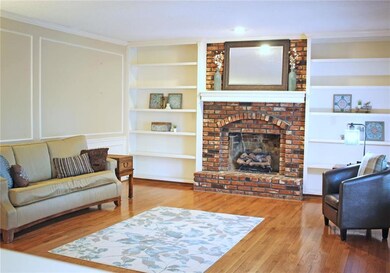 Living room with wood floors, built-ins and firepl