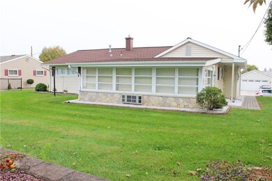 Rear yard view of home and 4 season room