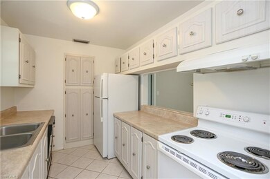 Kitchen featuring sink, range, white cabinets, lig
