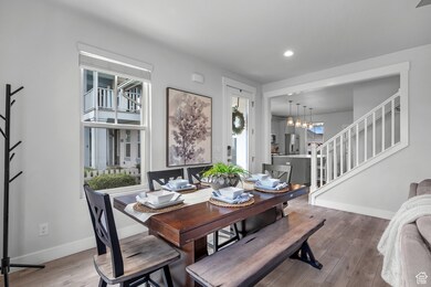 Dining room with stairway, hardwood / wood-style flooring, a chandelier, and recessed lighting