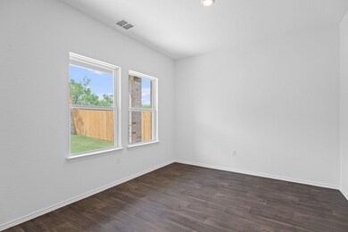 Empty room with baseboards, visible vents, and da