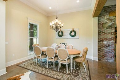 The Formal Dining has great views of the front lawn, and is open to the Foyer, Den and has great cypress beam!