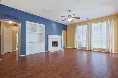 Large living room with fireplace and large windows overlooking the backyard