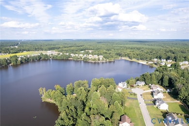 Aerial view of property's location featuring a heavily wooded area and a large body of water
