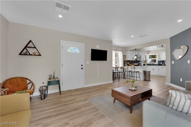 Living room featuring baseboards, light wood-style