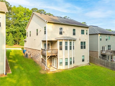 Rear view of property featuring central AC