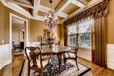 Gorgeous finishes including wainscoting, coffered ceilings, a beautiful chandelier and custom molding set apart this dining room.