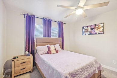 Bedroom featuring baseboards, ceiling fan, and car