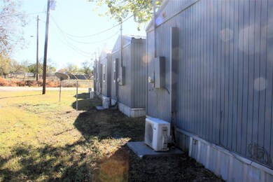 View of side of home featuring ac unit and a lawn