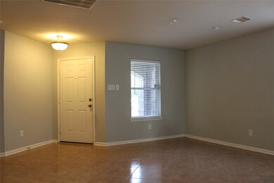 Living room features tile flooring and designer paint throughout.