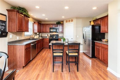 Amazing kitchen has large island w/bar top, walk-in pantry, maple cabinets, & laminate flooring.