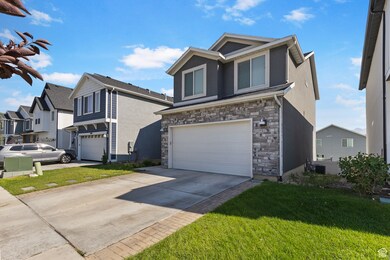 View of front of home featuring stone siding, an attached garage, concrete driveway, a front lawn, and stucco siding