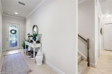 Foyer entrance featuring crown molding and light t