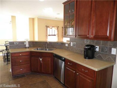 Kitchen. Tile floors~ Stainless Dishwasher and Double sinks~ Glass front Cabinetry to show off your favorite pieces!
