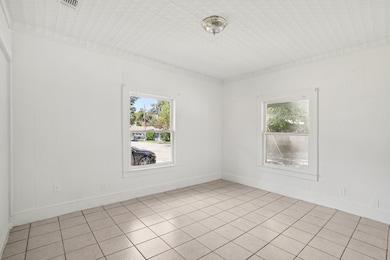 Downstair unit family room with light tile patterned floors and baseboards
