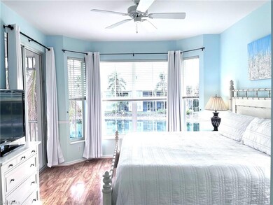Bedroom with wood-type flooring, multiple windows,