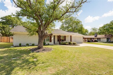 Ranch-style home with a front yard, a garage, fenc